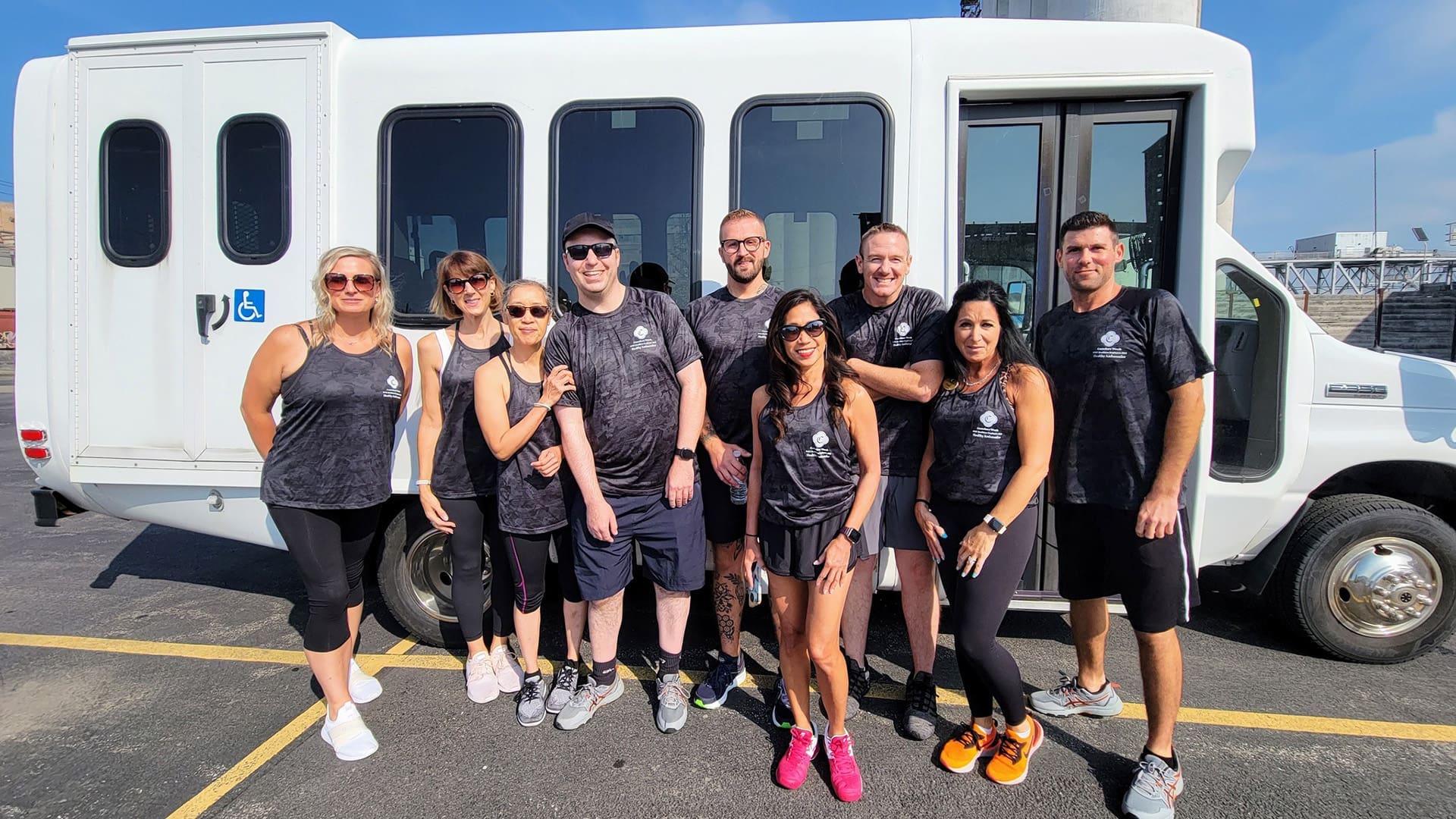 Canterbury Woods team standing in from of a white bus wearing matching activewear shirts
