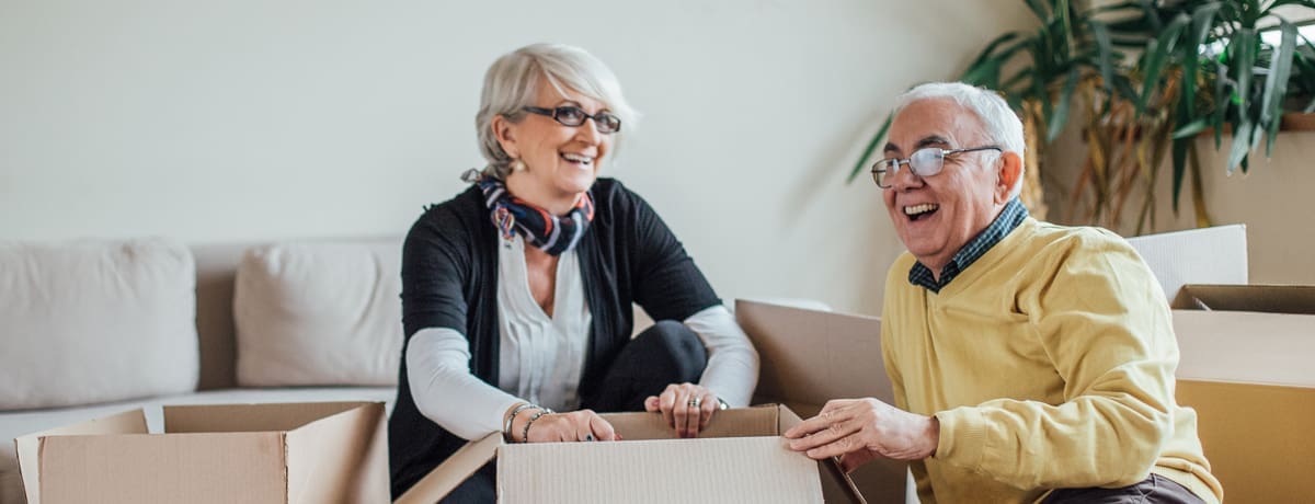 Senior couple packing moving boxes